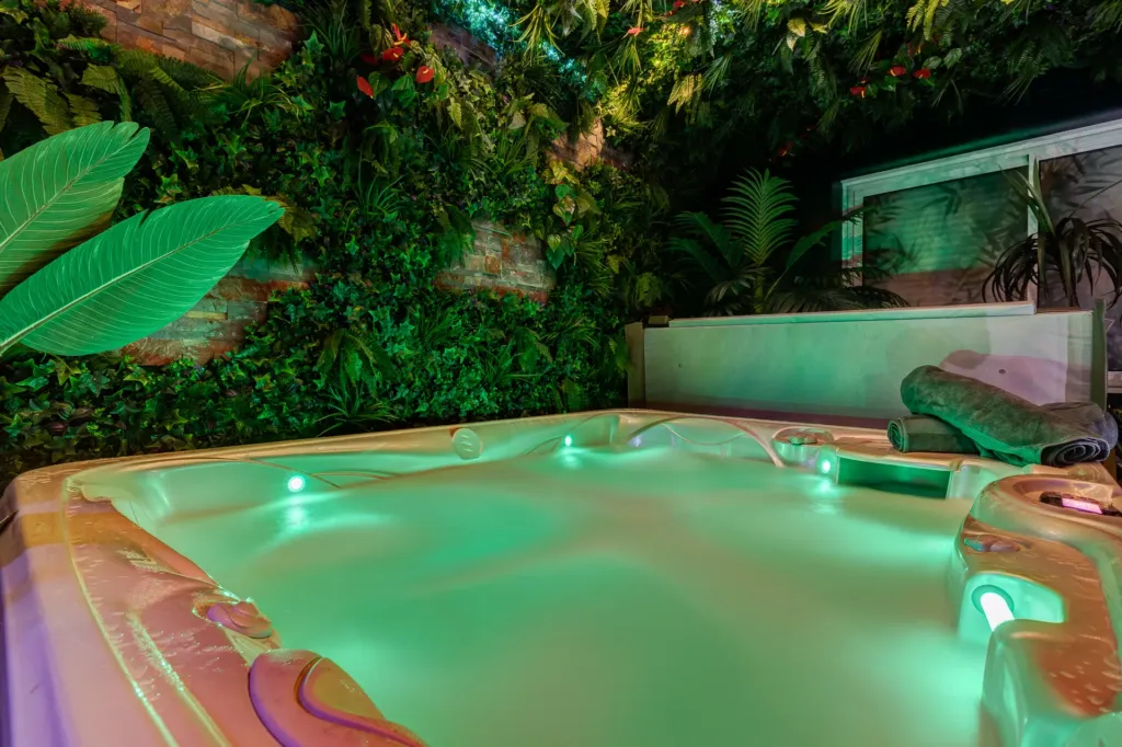 Nuit insolite en love room : le jacuzzi au cœur du décor tropical de la Jungle Love Room, à Toulouse
