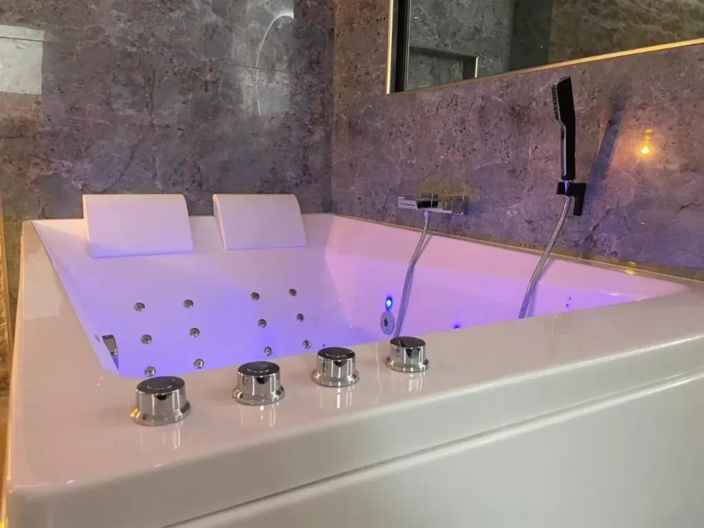 Les Jardins Secrets : baignoire spa en lumière violette, love room à Dijon