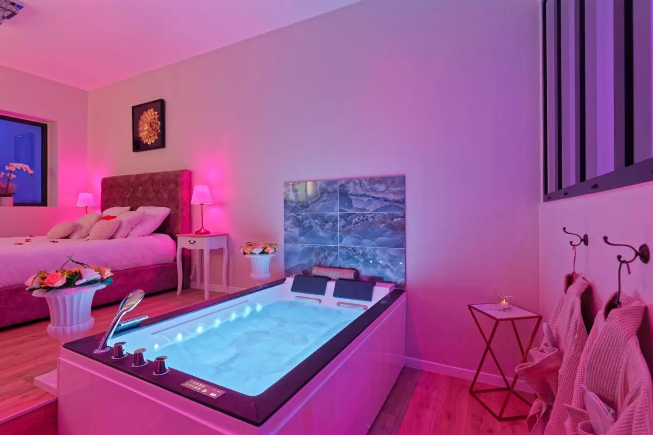 Romance Spa Nuit d'Amour : jacuzzi et lit en lumière rose, love room au Havre
